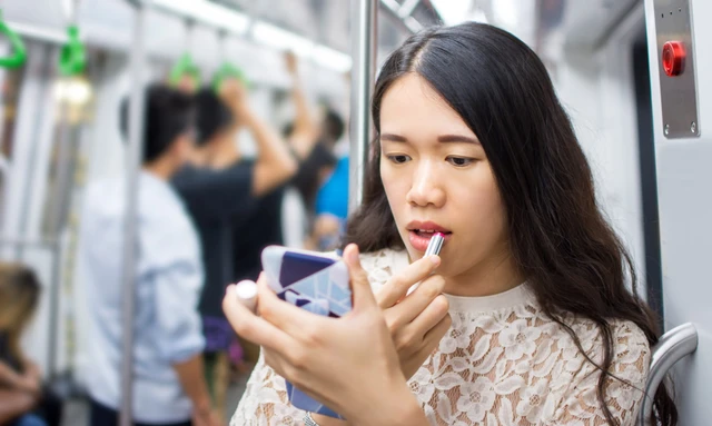 電車の中でメイクする人