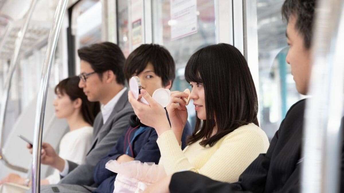 電車の中でメイクする人