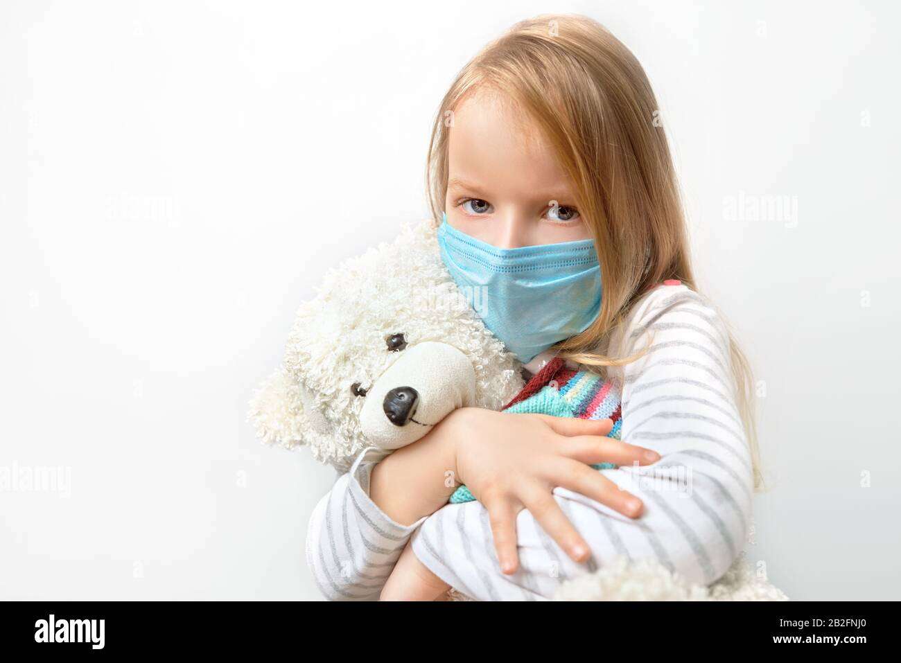 Coronavirus covid-19 and pollution protection concept. little child girl hugging teddy bear doll with wearing mask to against corona virus and air Stock Photo - Alamy
